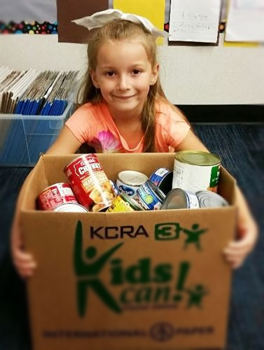 Girl holding a box of cans